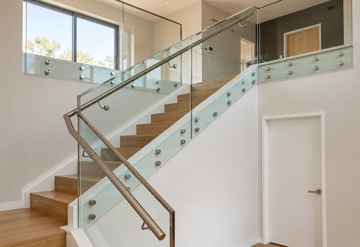 Indoor glass stair balustrade with silver handrail and standoffs