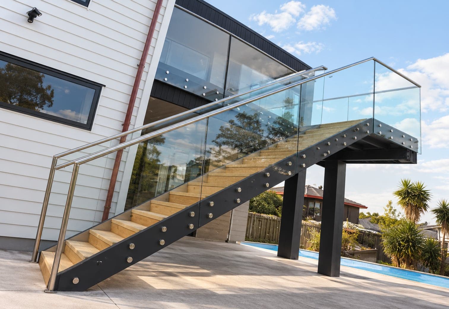 Outdoor glass stair balustrade with silver handrail