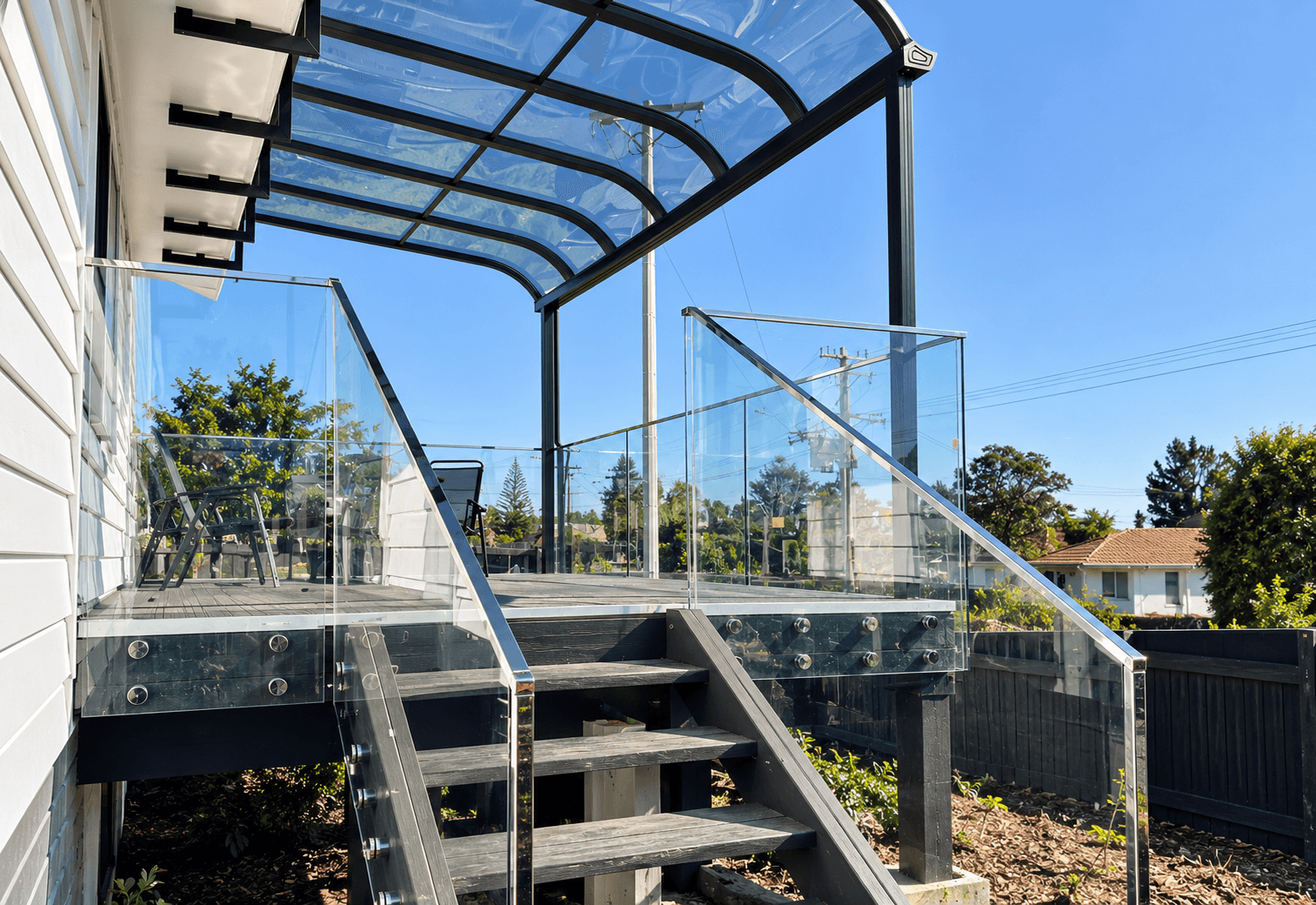 Outdoor deck stairs with glass panels and a silver frame